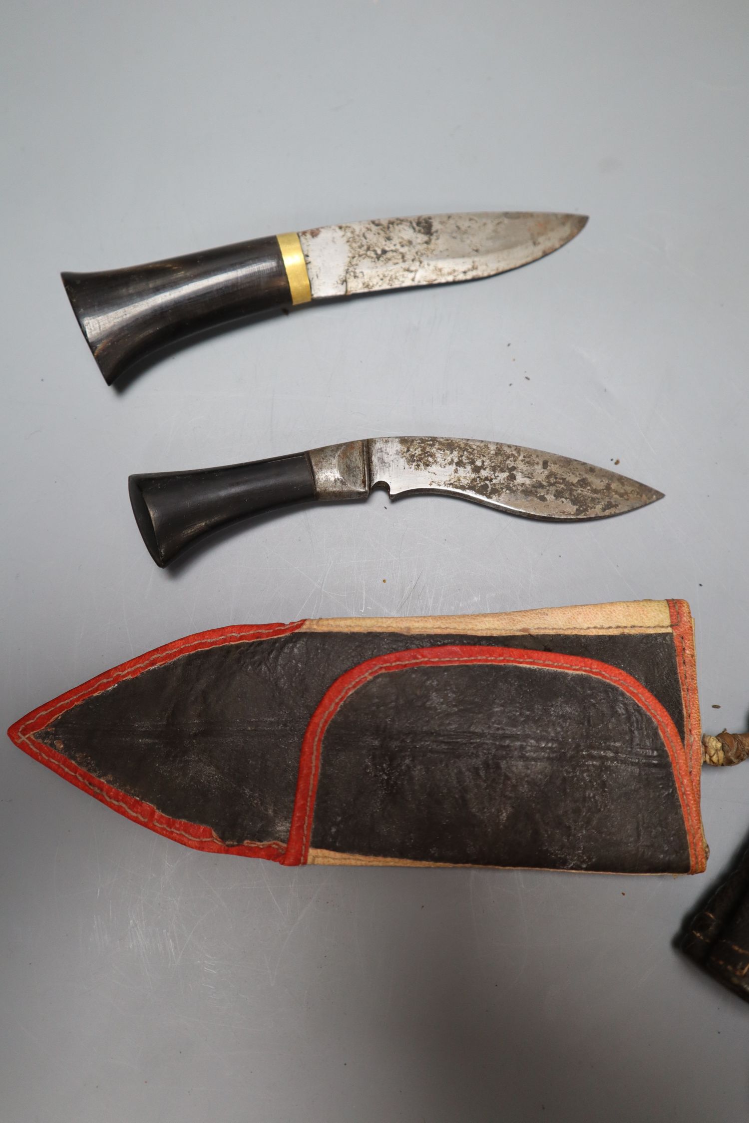 A kukri with skinning knives, leather sheath with elaborate embossed gilt metal mounts, blade 36cm